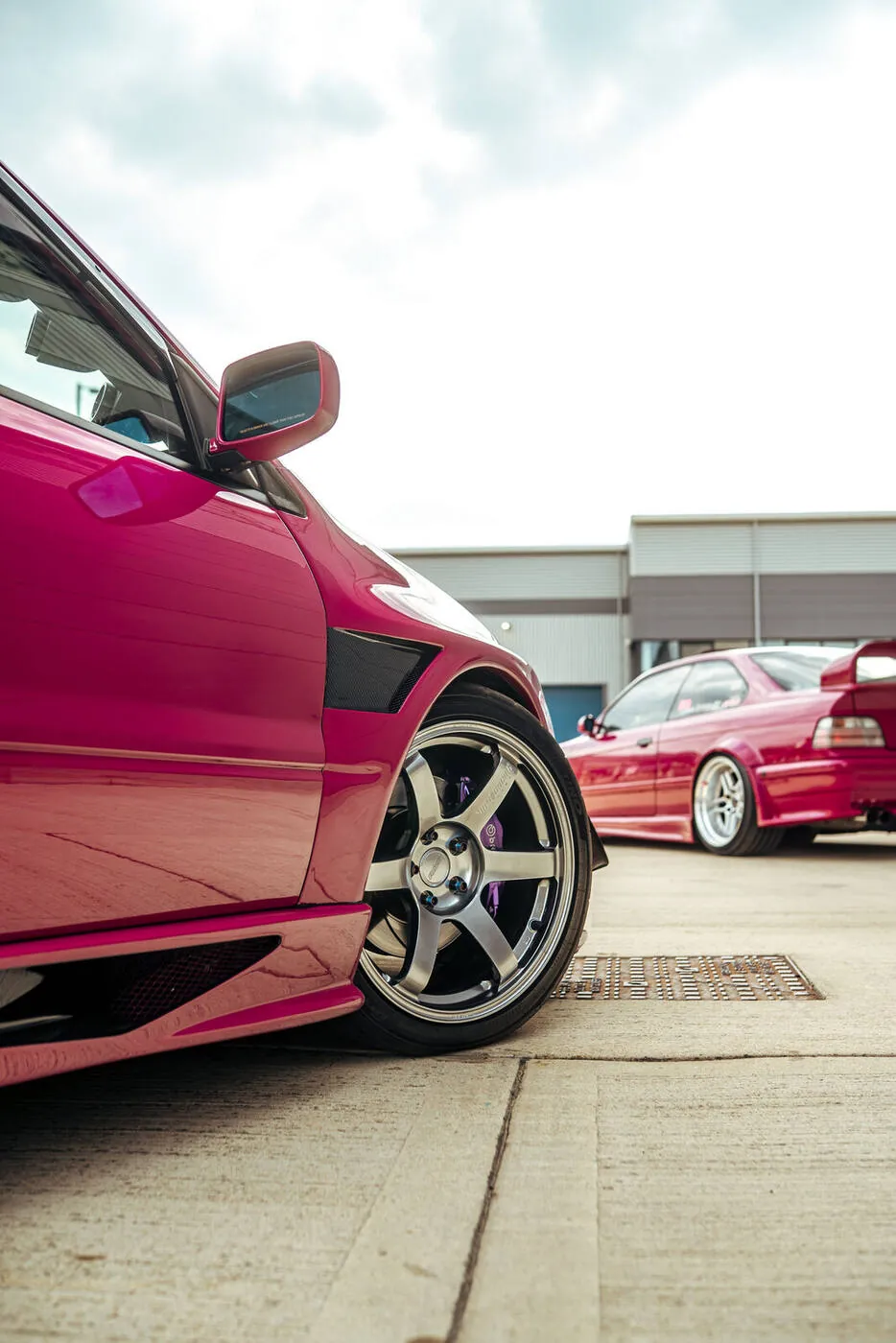 Magenta Evo side on, six spoke wheel and a second Evo parked behind