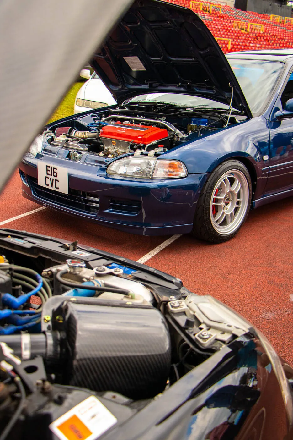 Blue Civic with its bonnet up and a red VTEC engine, a second engine bay in the foreground